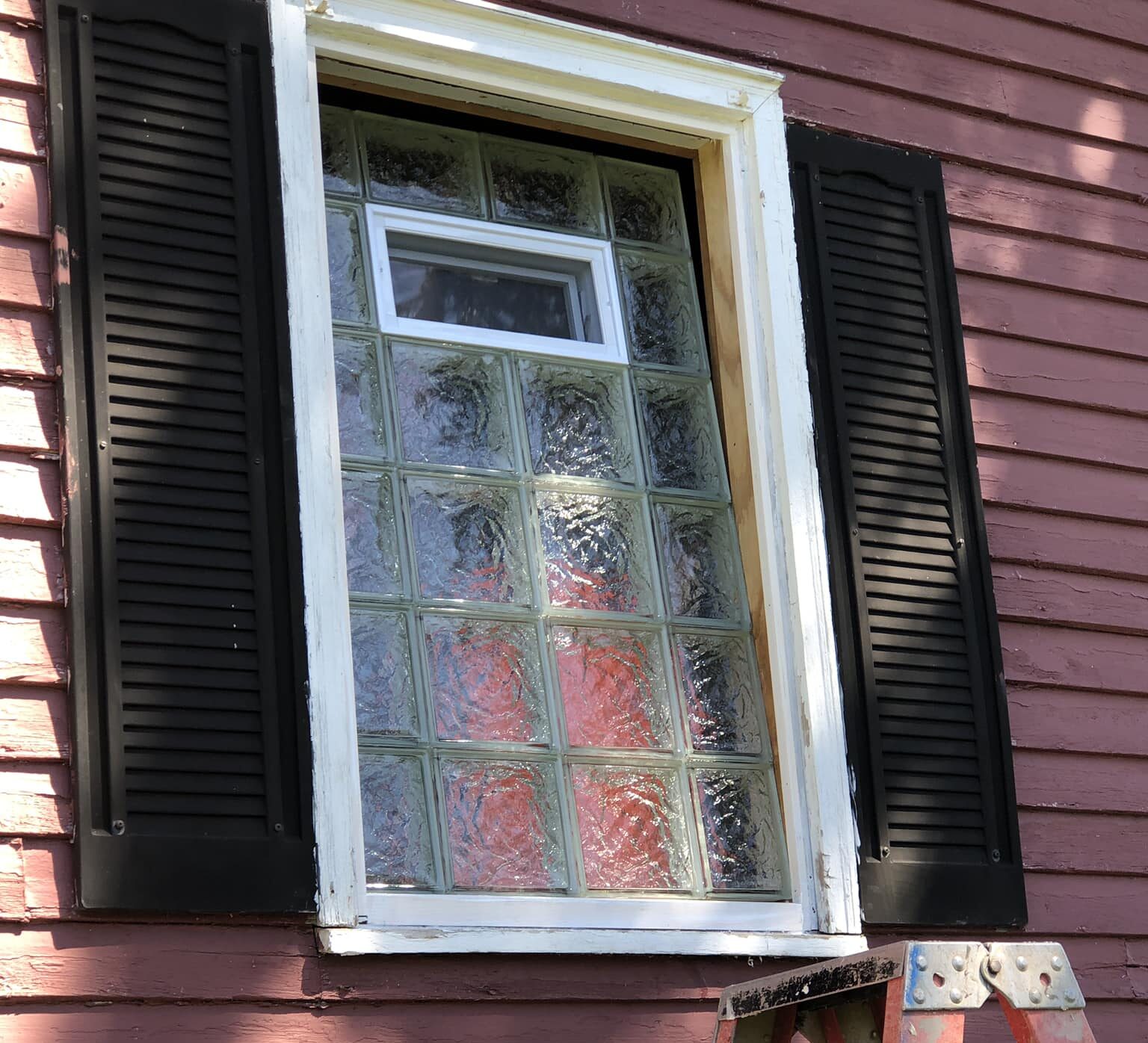 Man installing glass block window in a basement